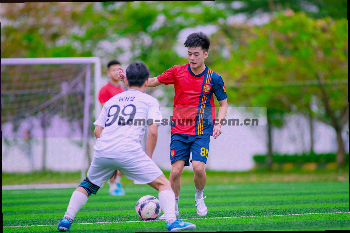 白天露天球场上球员围成一圈听教练讲话，场边摆着一块简易记分牌